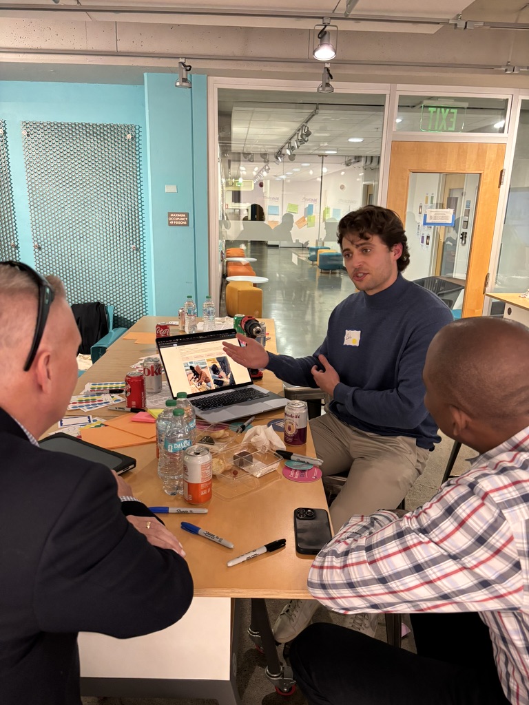 Facilitator presenting to small group of participants around table