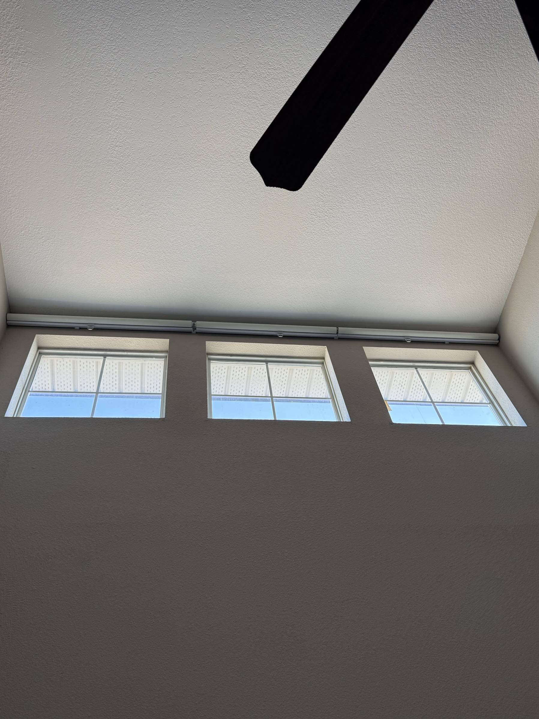 Three high windows with blinds installed