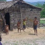 Kinder vor einem Lehmhaus