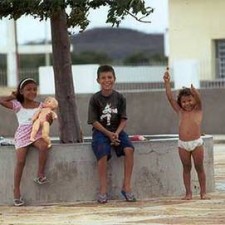 Drei Kinder auf einer Mauer