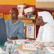Einheimischer Lehrer und Ordensschwester arbeiten gemeinsam am Computer
