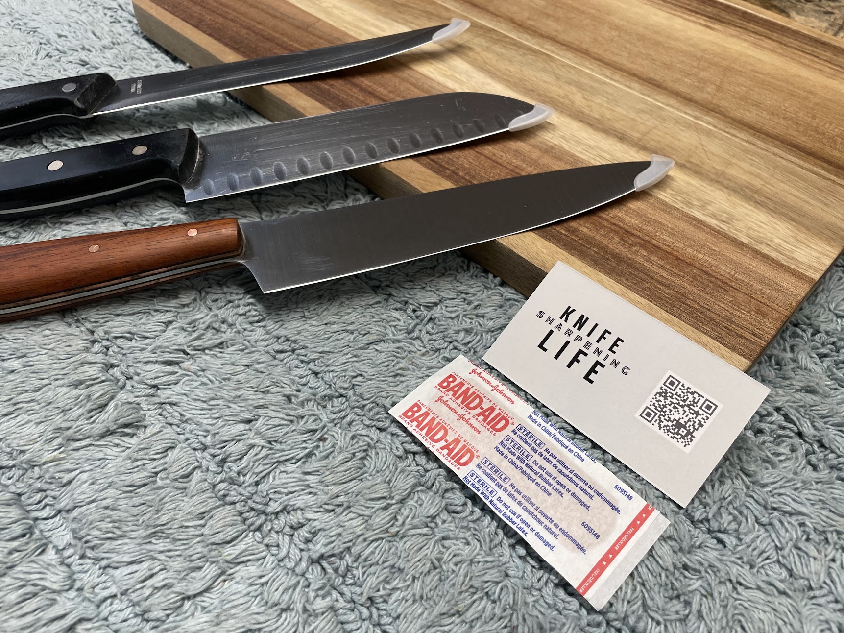 Knife Life Sharpening business card with kitchen knives on blue towel