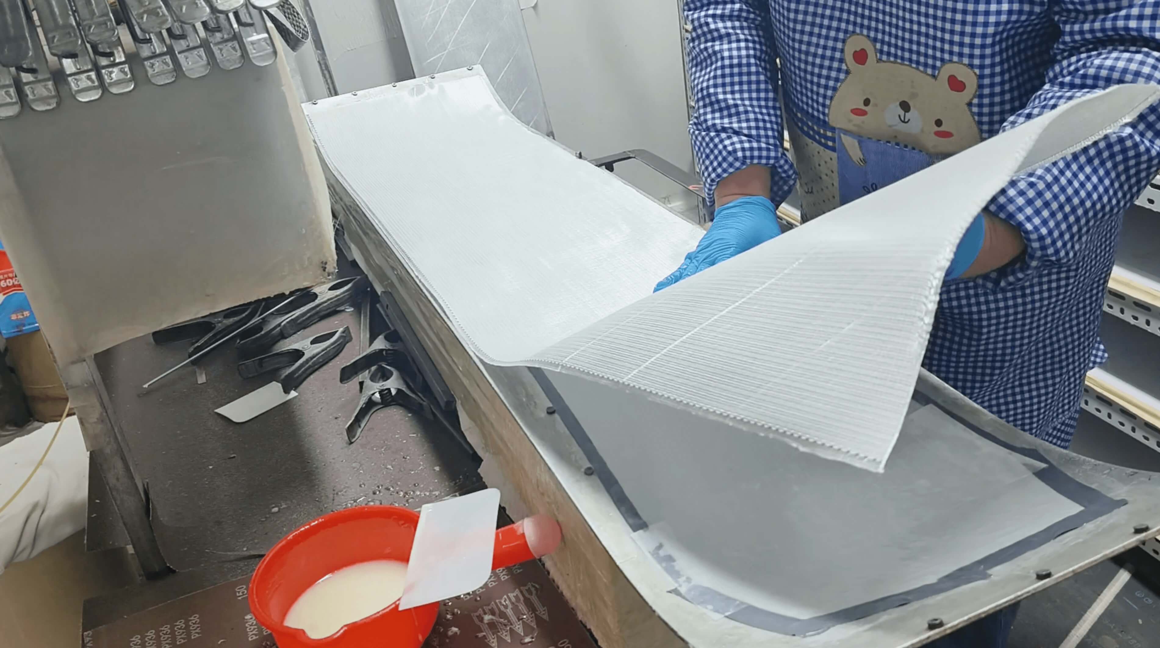 Triaxial fiberglass sheet being laid into the mold over the base