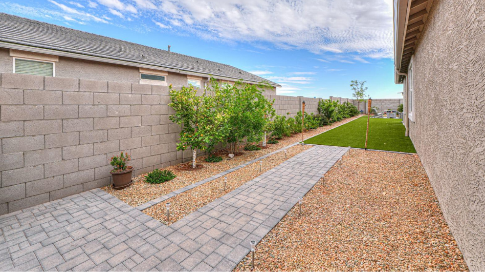 Side yard paver walkway with turf strip and fresh landscaping