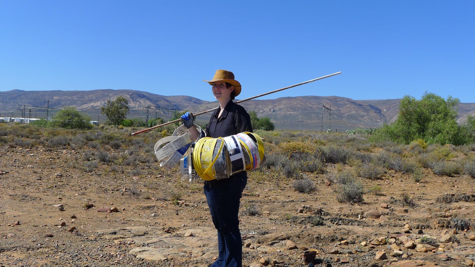 Artist holding surveying equipment at site