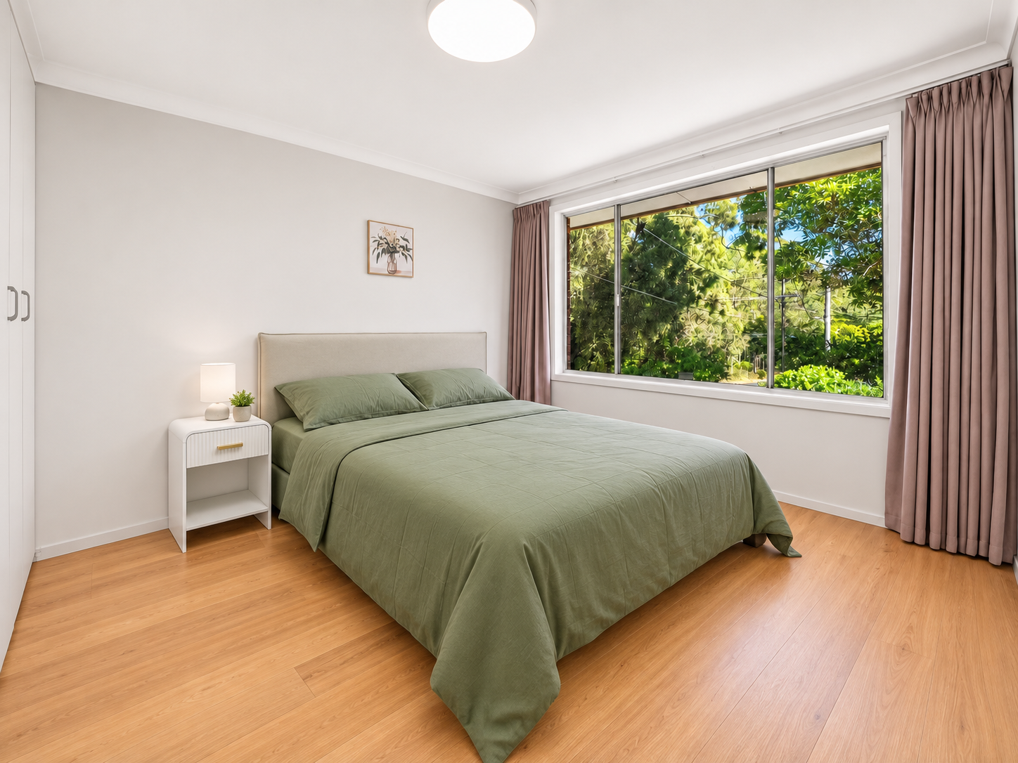 Main bedroom with natural light and green bedding