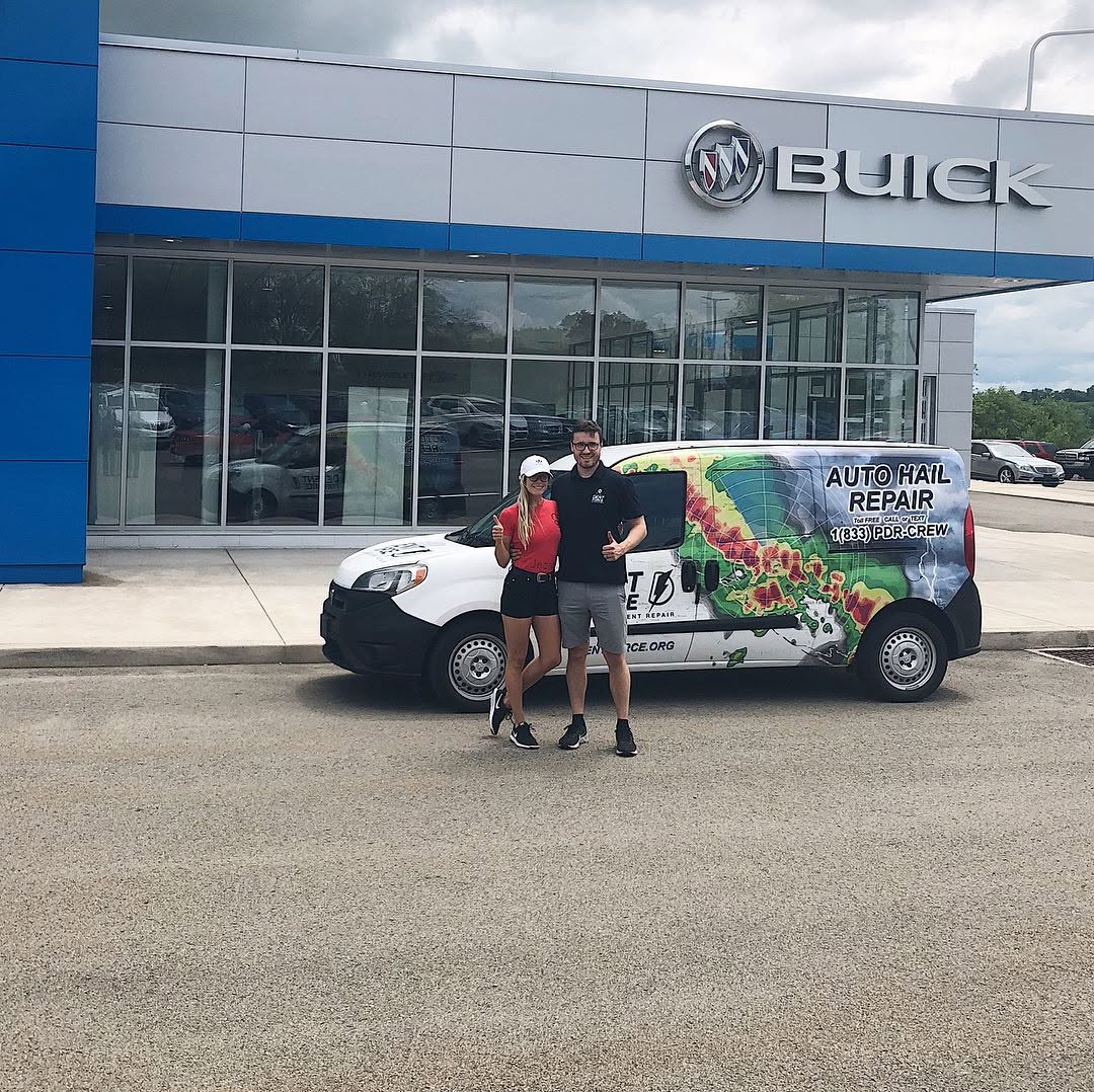 Dent Force team with their branded van in front of a Buick dealership