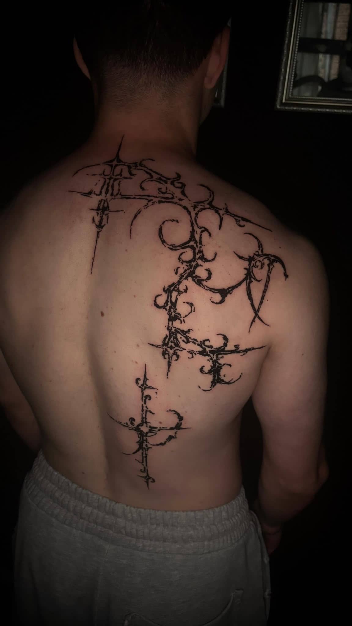 Blackwork grosses ornamentales Tribal-Ruecken-Tattoo mit Kreuz-Elementen
