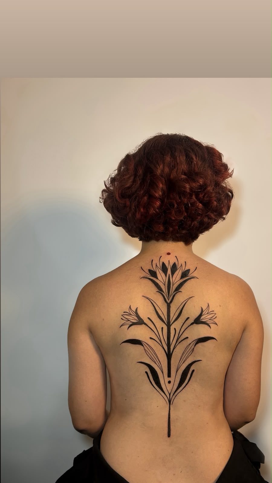 Tatuagem em costas com design vertical simétrico e flores