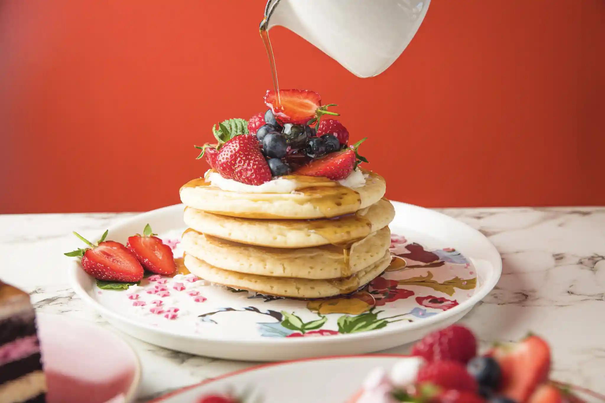 Fluffy pancakes with fresh berries and syrup