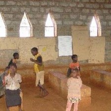 Kinder spielen in einem unfertigen Steingebäude mit gotischen Bogenfenstern