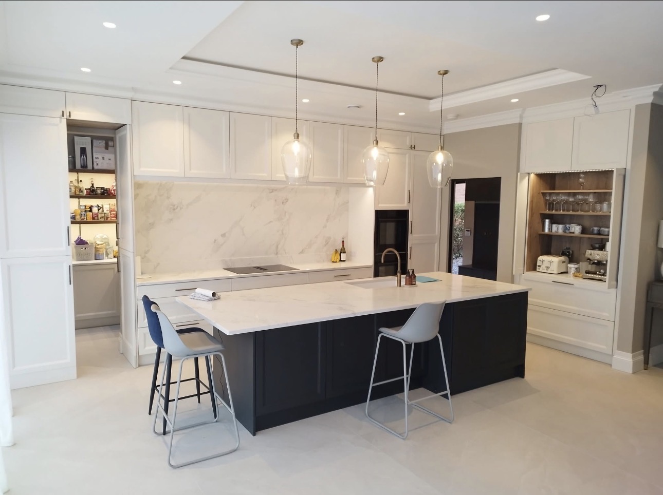 Modern bespoke kitchen with white shaker cabinets, dark navy island and marble countertops in Newry