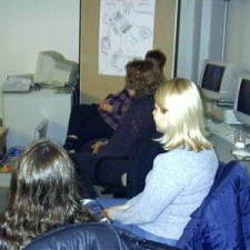 Drei Frauen im Seminarraum mit Computern im Hintergrund