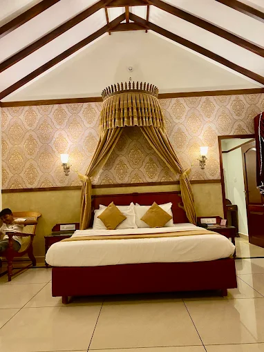Suite bedroom with a canopy bed and a high peaked timber ceiling