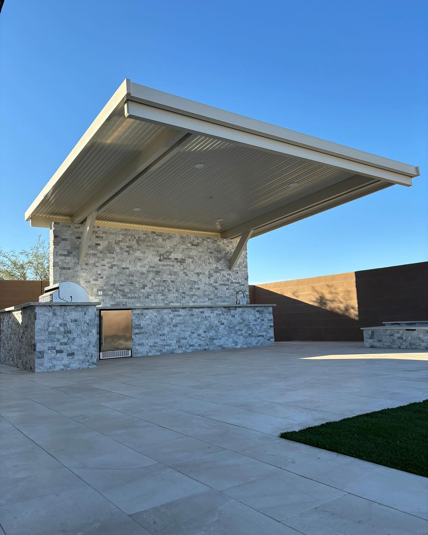 Poolside patio cover with putting green and desert landscaping