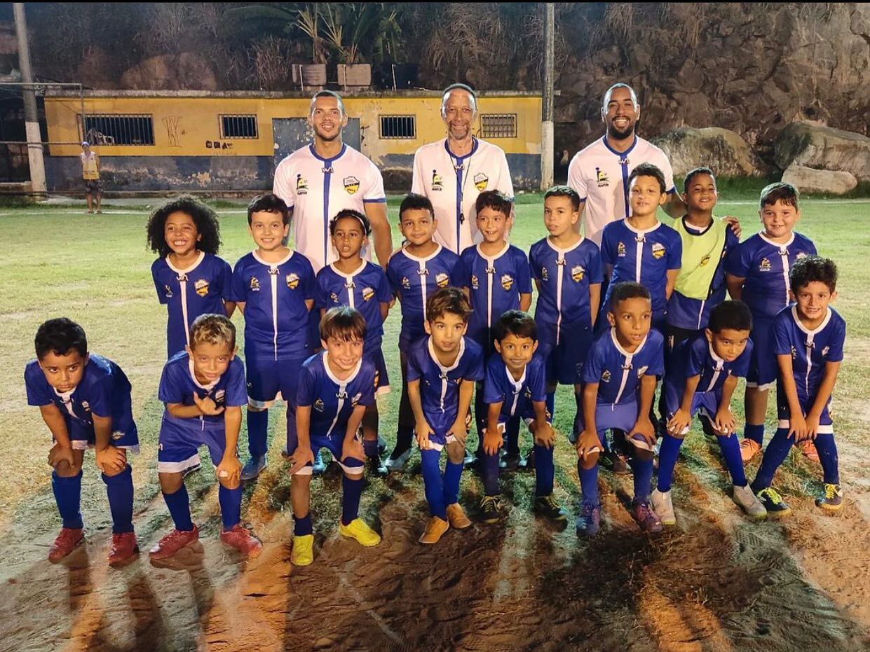 Time reunido em campo à noite com os educadores