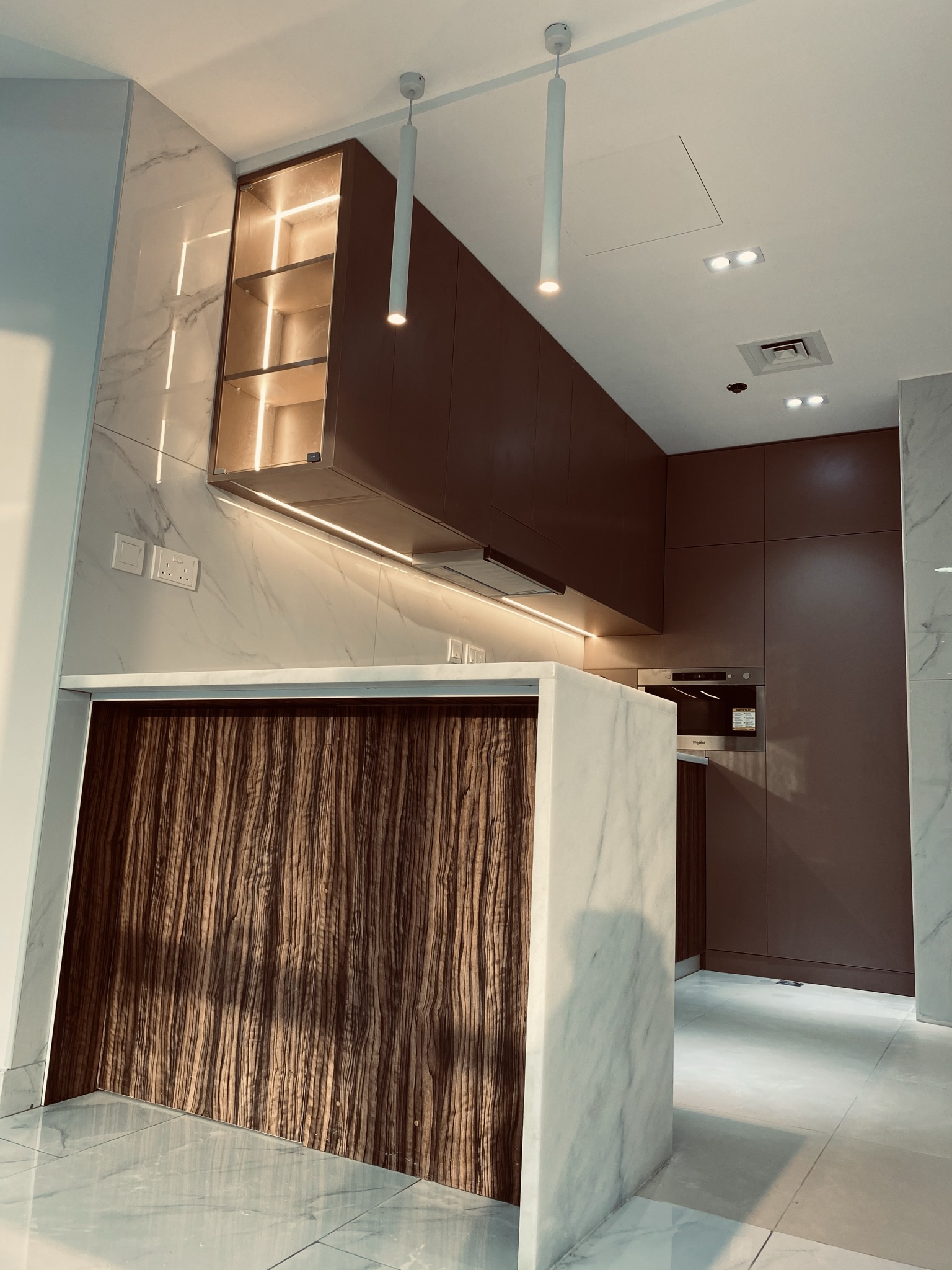 Modern kitchen with burgundy cabinets and marble island