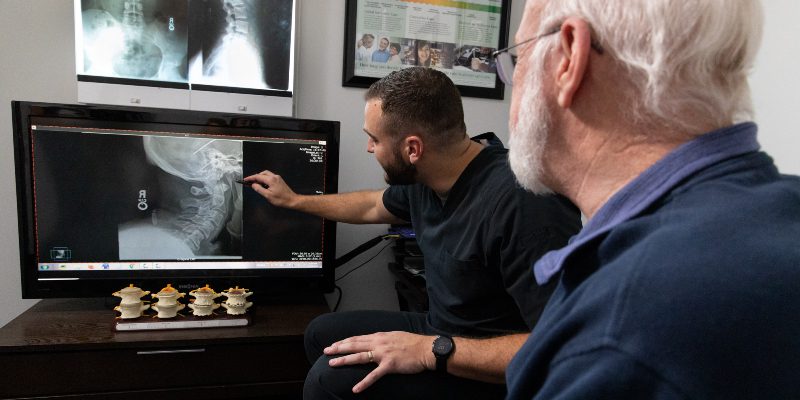 Chiropractor reviewing X-ray images for diagnosis