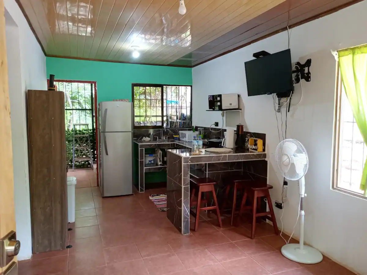 Cocina con barra desayunadora, fregadero y refrigeradora