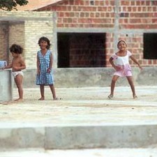 Drei Kinder spielen auf einem Betonplatz