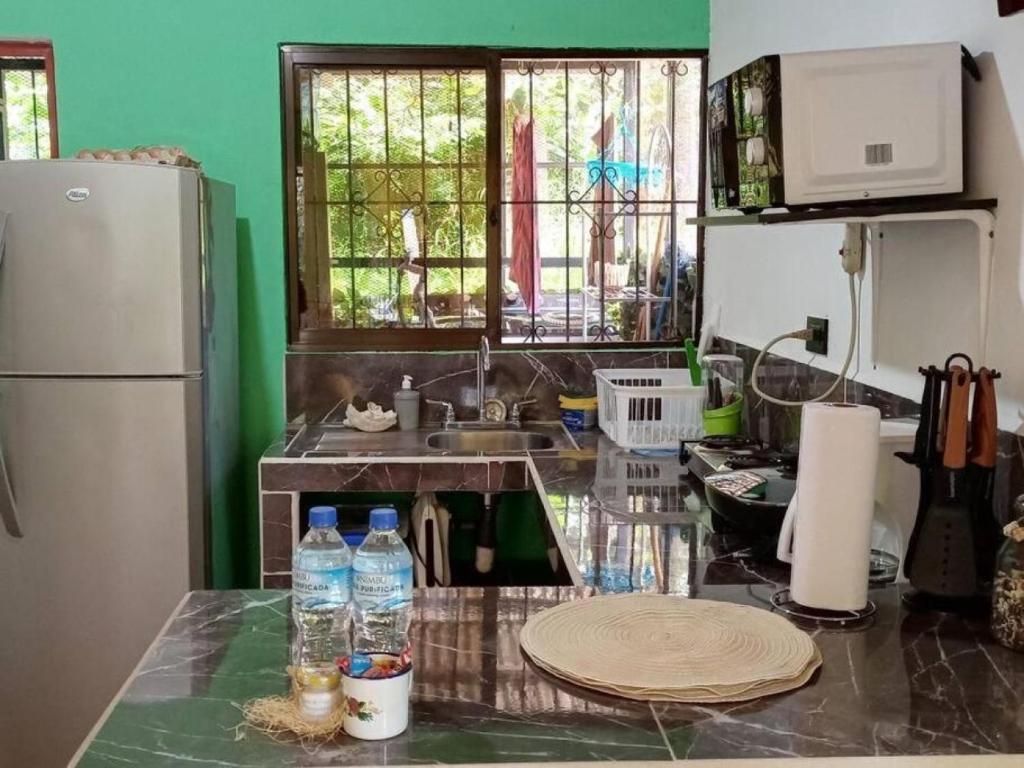Cocina con refrigeradora, fregadero, estufa y superficies de piedra oscura