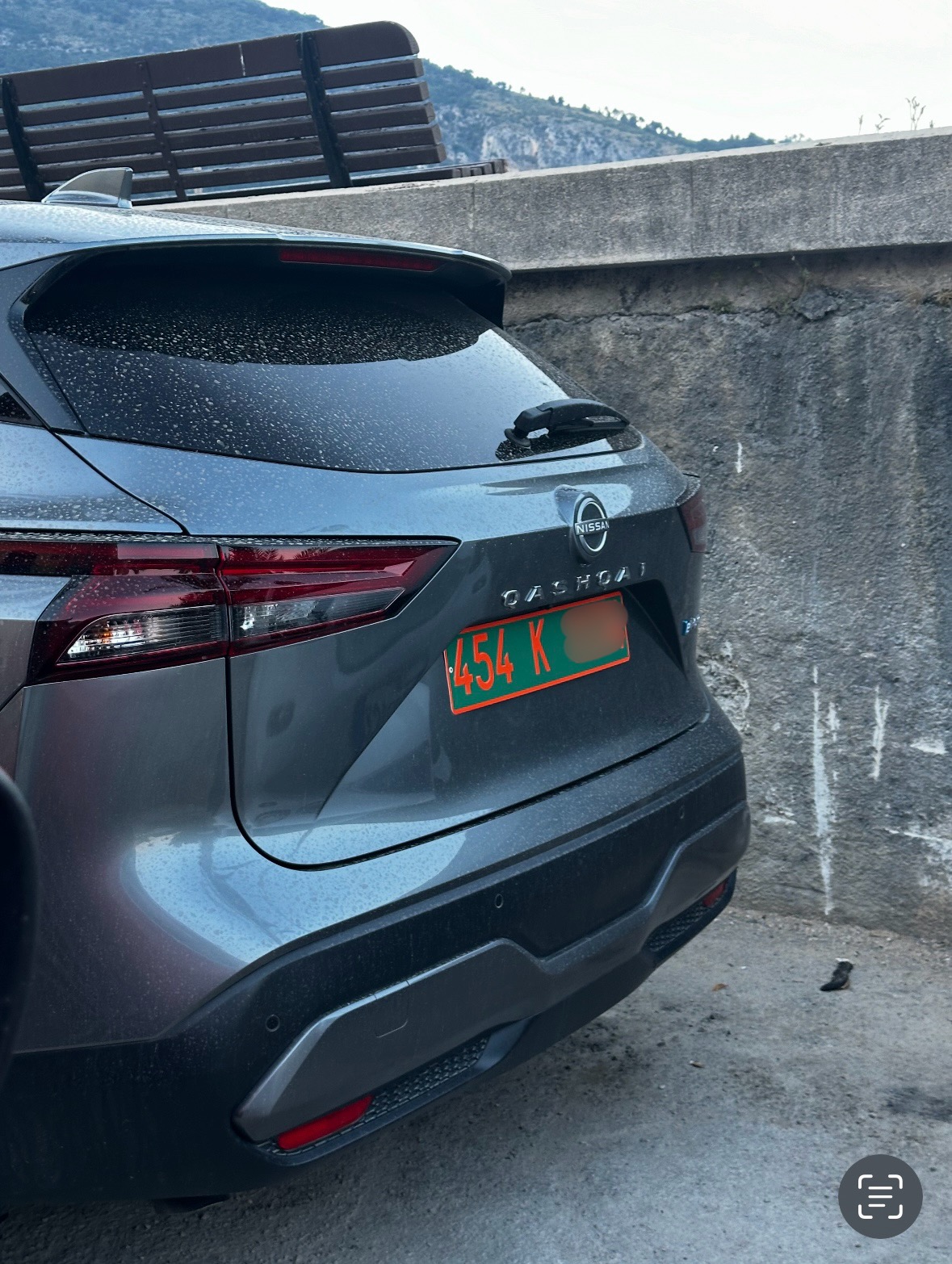 Plaque 454 K — ITER (Cadarache), personnel technique Plaque diplomatique verte 454 K à caractères orange sur un Nissan Qashqai gris, photographié près d'un mur de béton — code 454 correspondant à ITER
