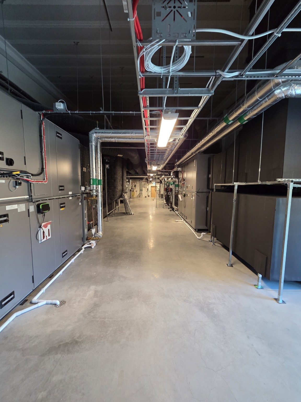 Tekniskt rum med ventilationsaggregat, kanaler och kabelstegar