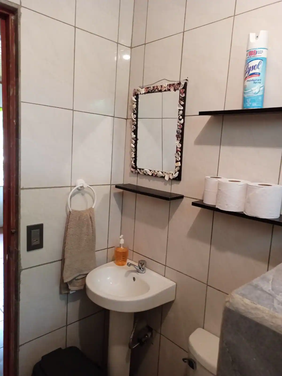 Baño con paredes de azulejo claro y lavamanos