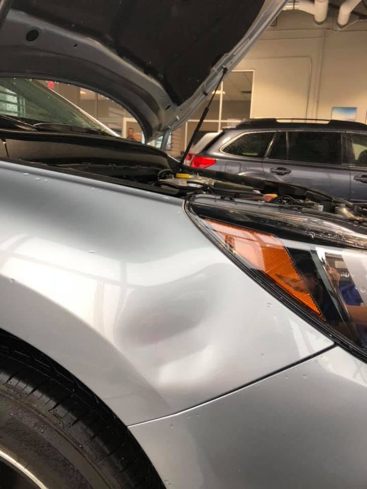 Silver SUV fender with large hail dent before PDR repair