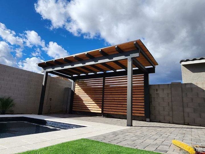Wood-beam patio cover framing a pool and travertine deck