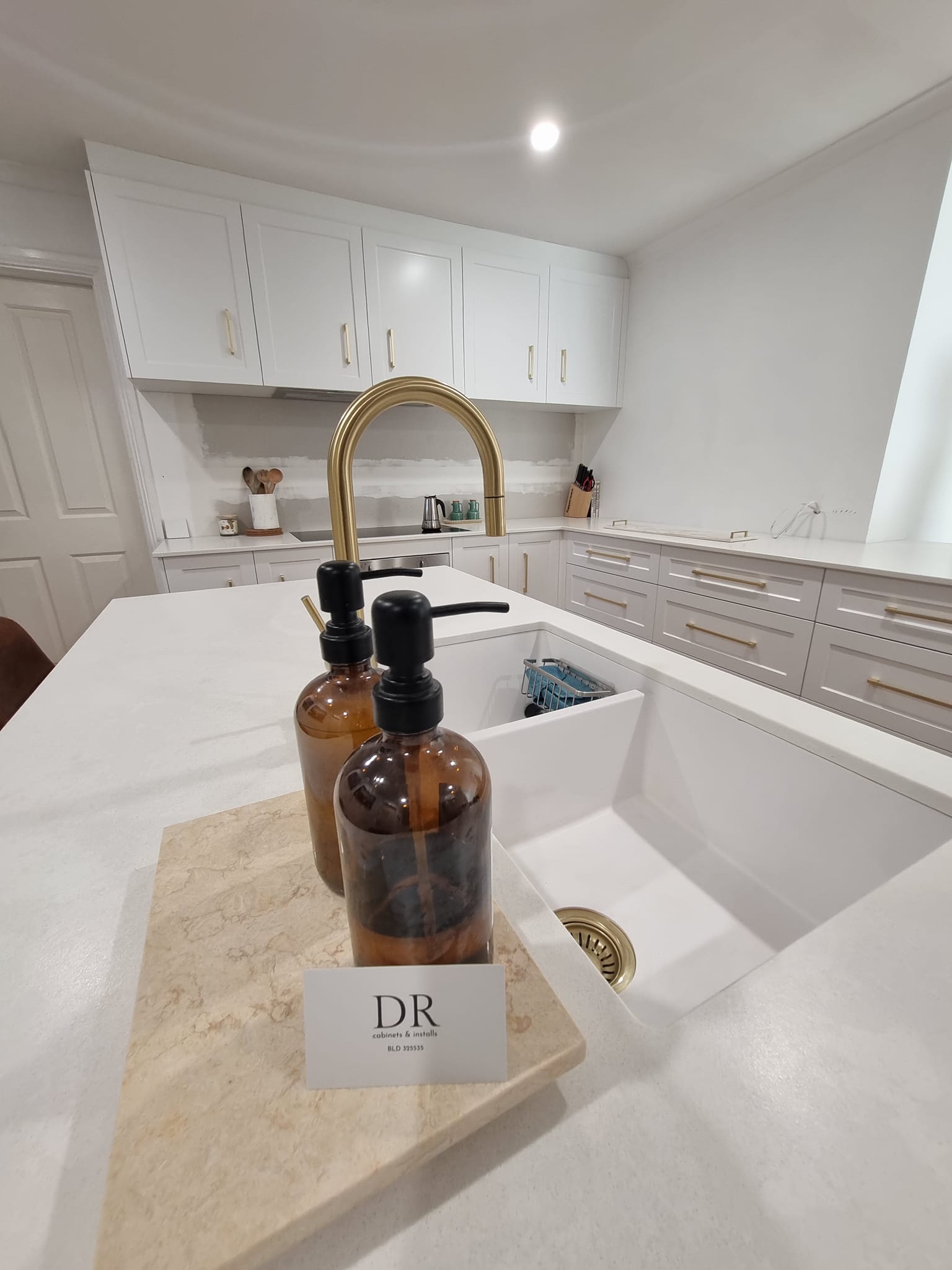 Modern white kitchen with gold tapware and shaker cabinets