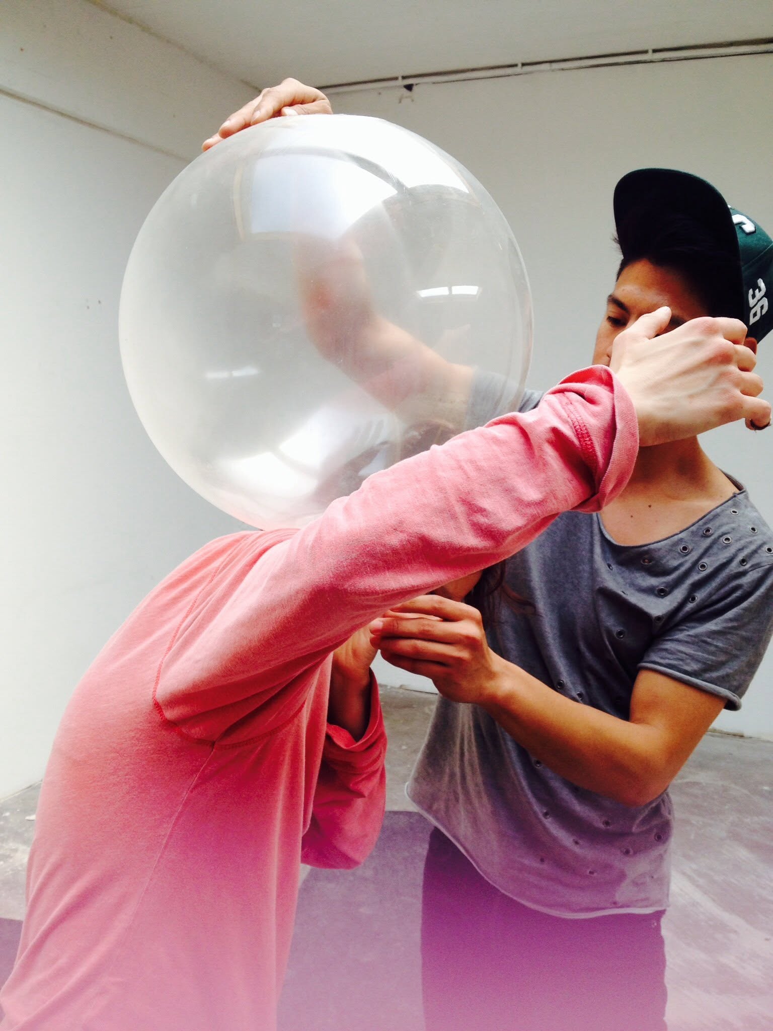Two dancers in close partner work, one holding a translucent sphere