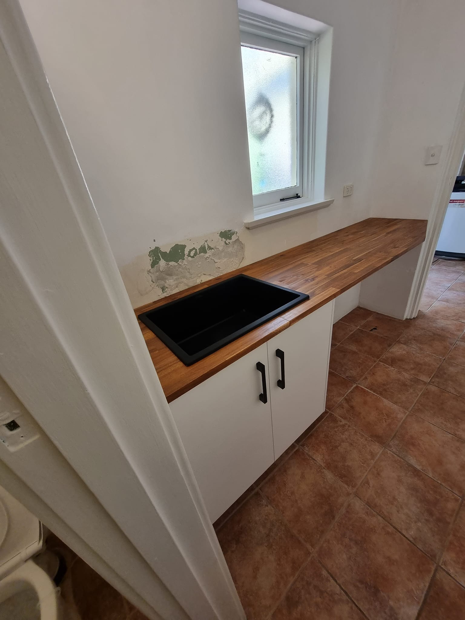 Laundry cabinet with timber benchtop and black sink