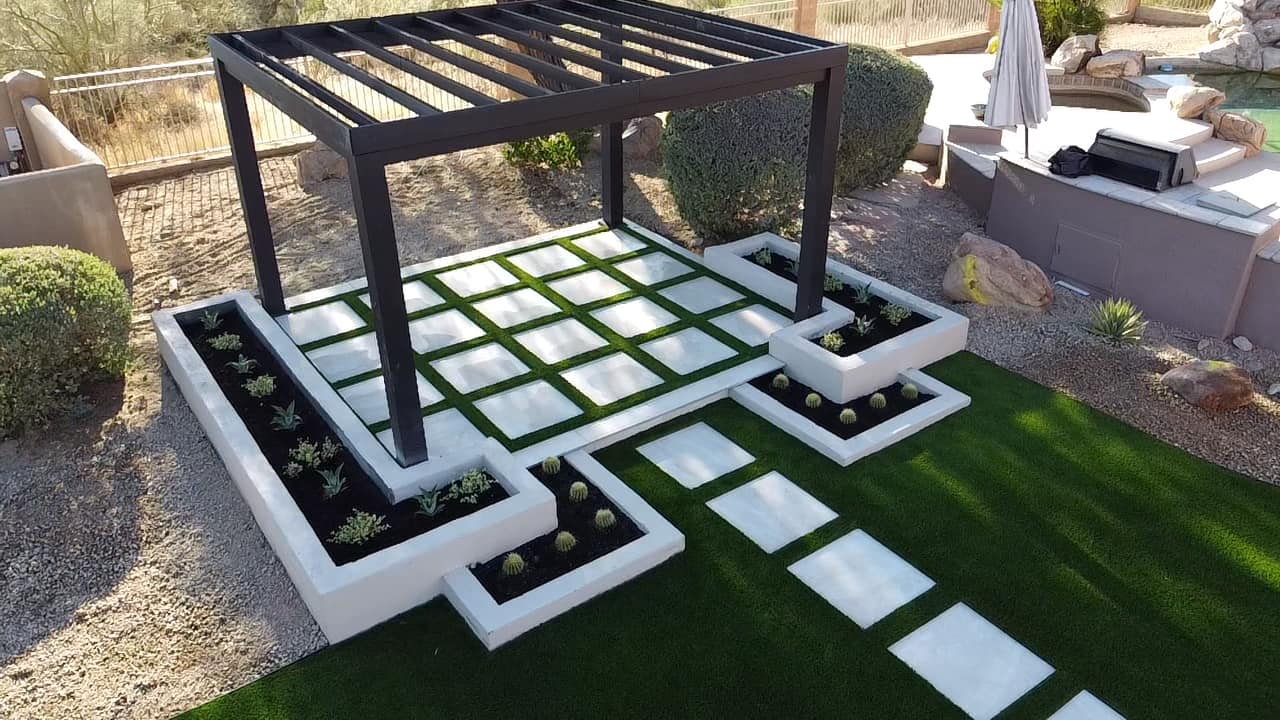 Large turf backyard lawn with shed, pool edge, and palm trees