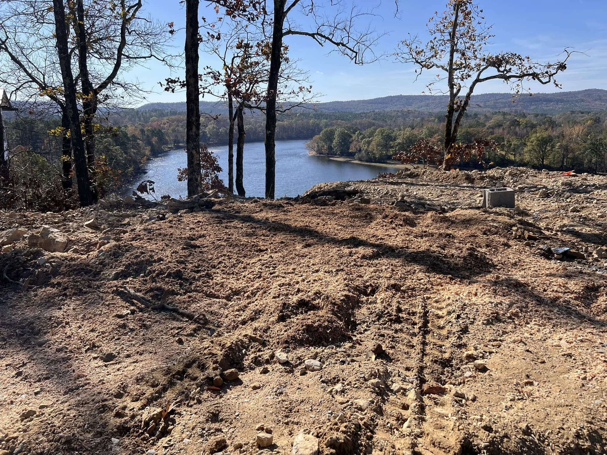 Completed lakefront lot clearing with scenic lake and mountain view