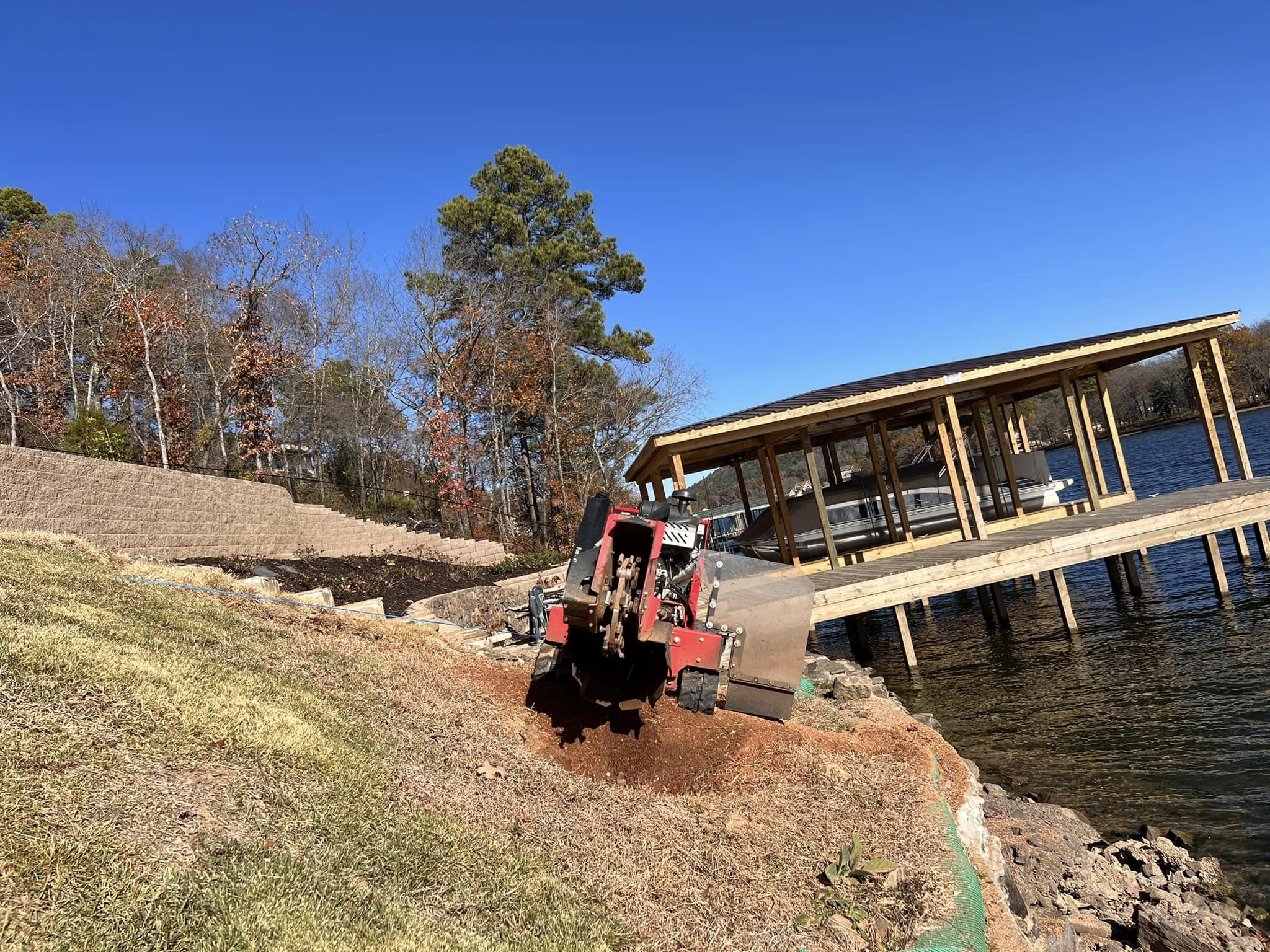 Stump grinding next to boat dock on lakefront property