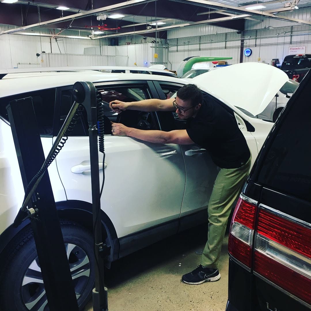 Dent Force PDR technician working on a vehicle door panel