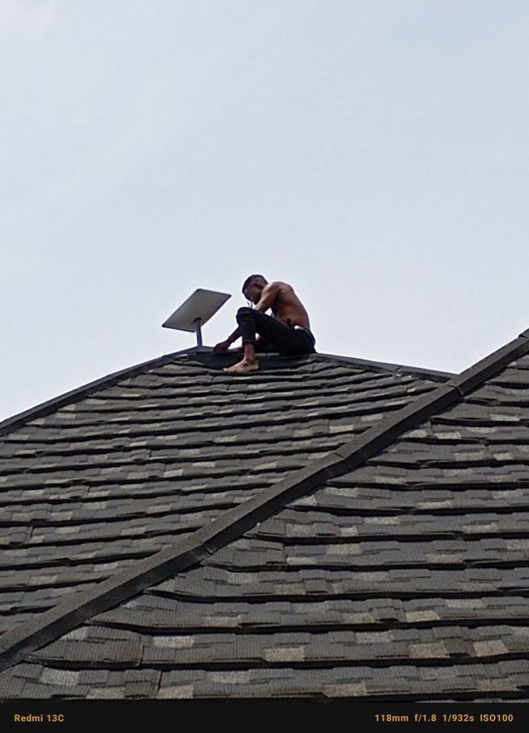 Technician on rooftop working on solar panel mounting