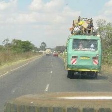 Vollbeladener grüner Matatu-Kleinbus auf der kenianischen Hauptstraße