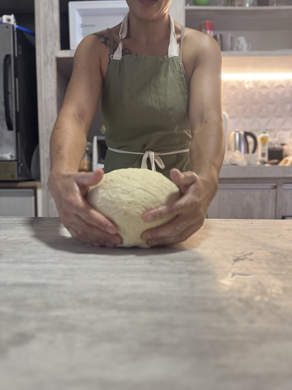 Mãos segurando massa de pão artesanal de fermentação natural