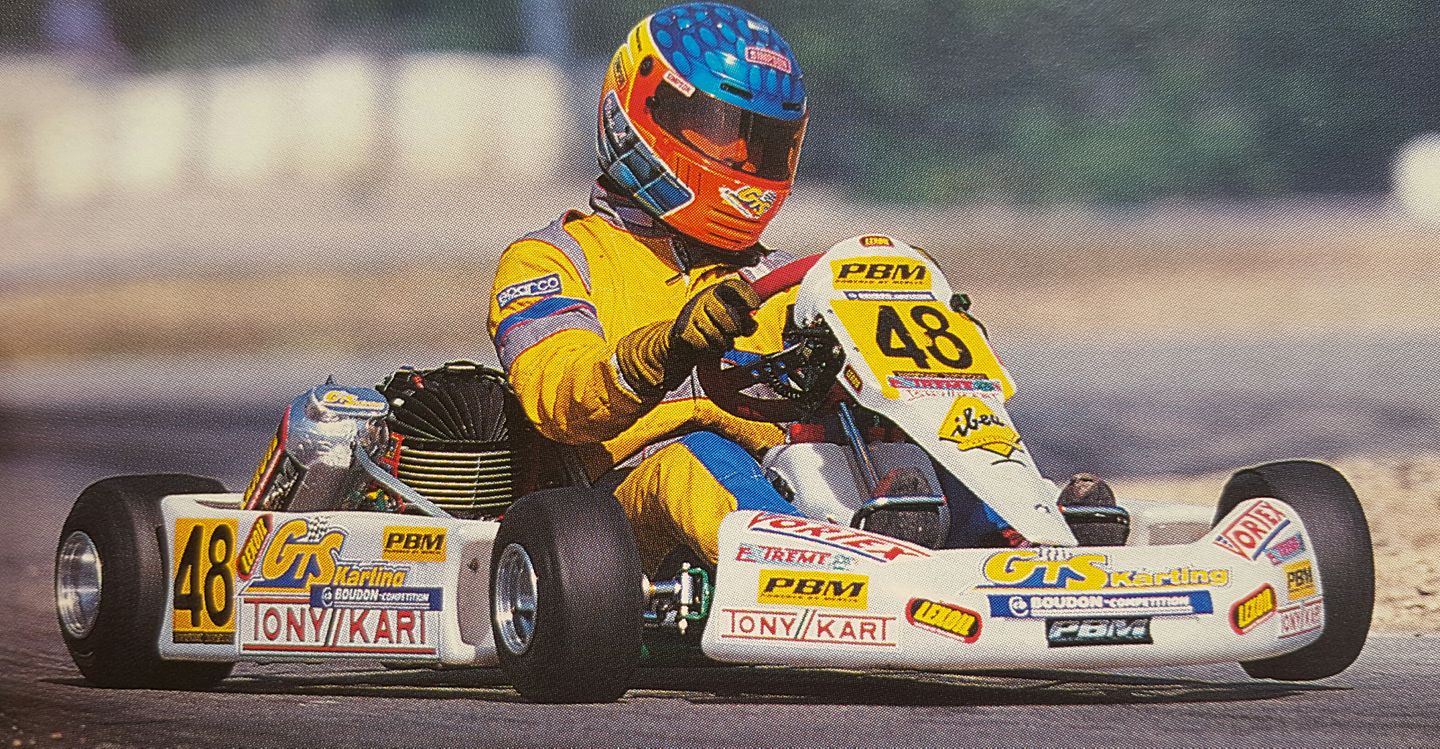 GTS Karting driver in yellow racing at speed