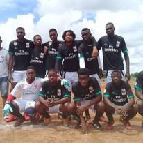 Team in dark jerseys on beach/sandy area