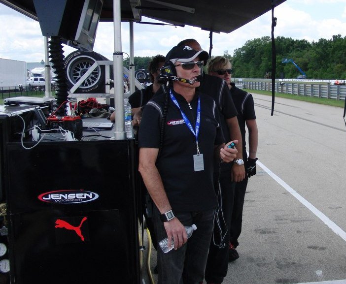 Christian Boudon on pit wall at Jensen Motorsport with headset and timing equipment