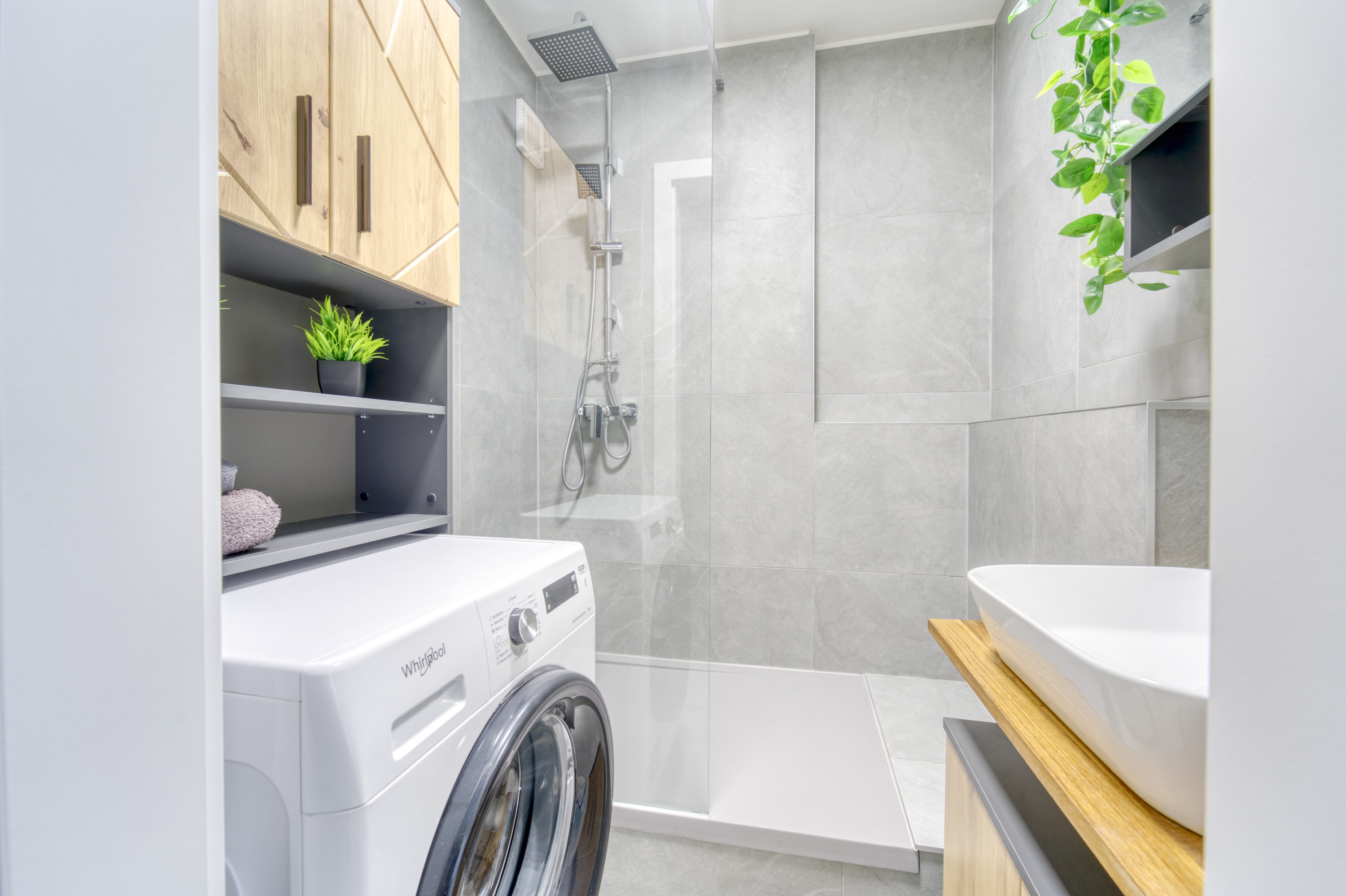Gray tiled bathroom with wood cabinetry