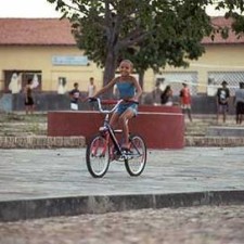 Kind auf dem Fahrrad auf dem Dorfplatz