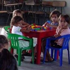 Drei Kinder am Tisch mit Lego-Bausteinen