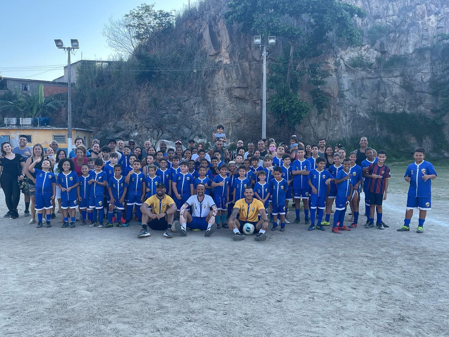 Crianças e familiares reunidos no campo