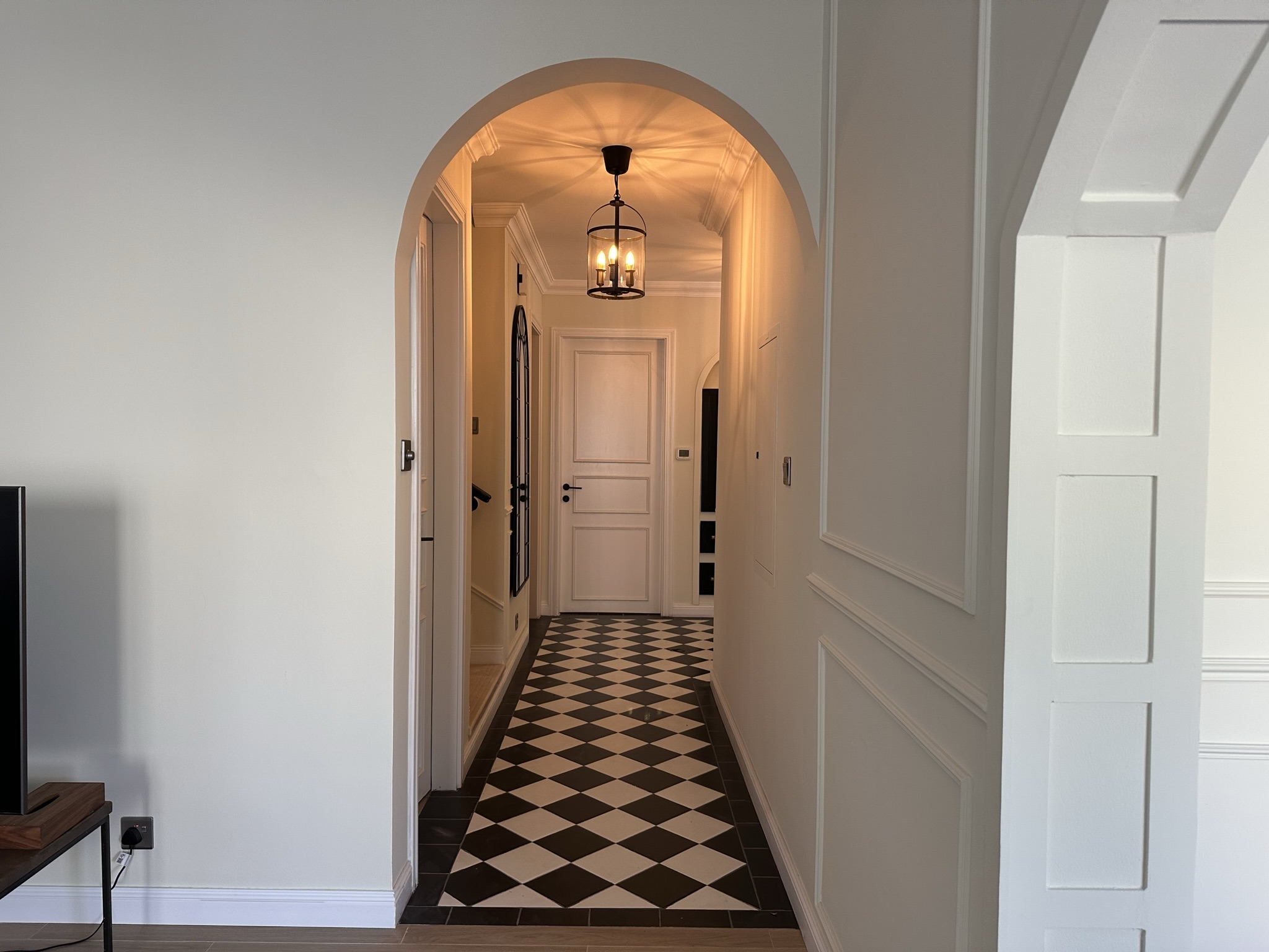 Classic hallway with arched entrance and diamond floor tiles