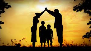 Family silhouettes forming protective shelter at sunset
