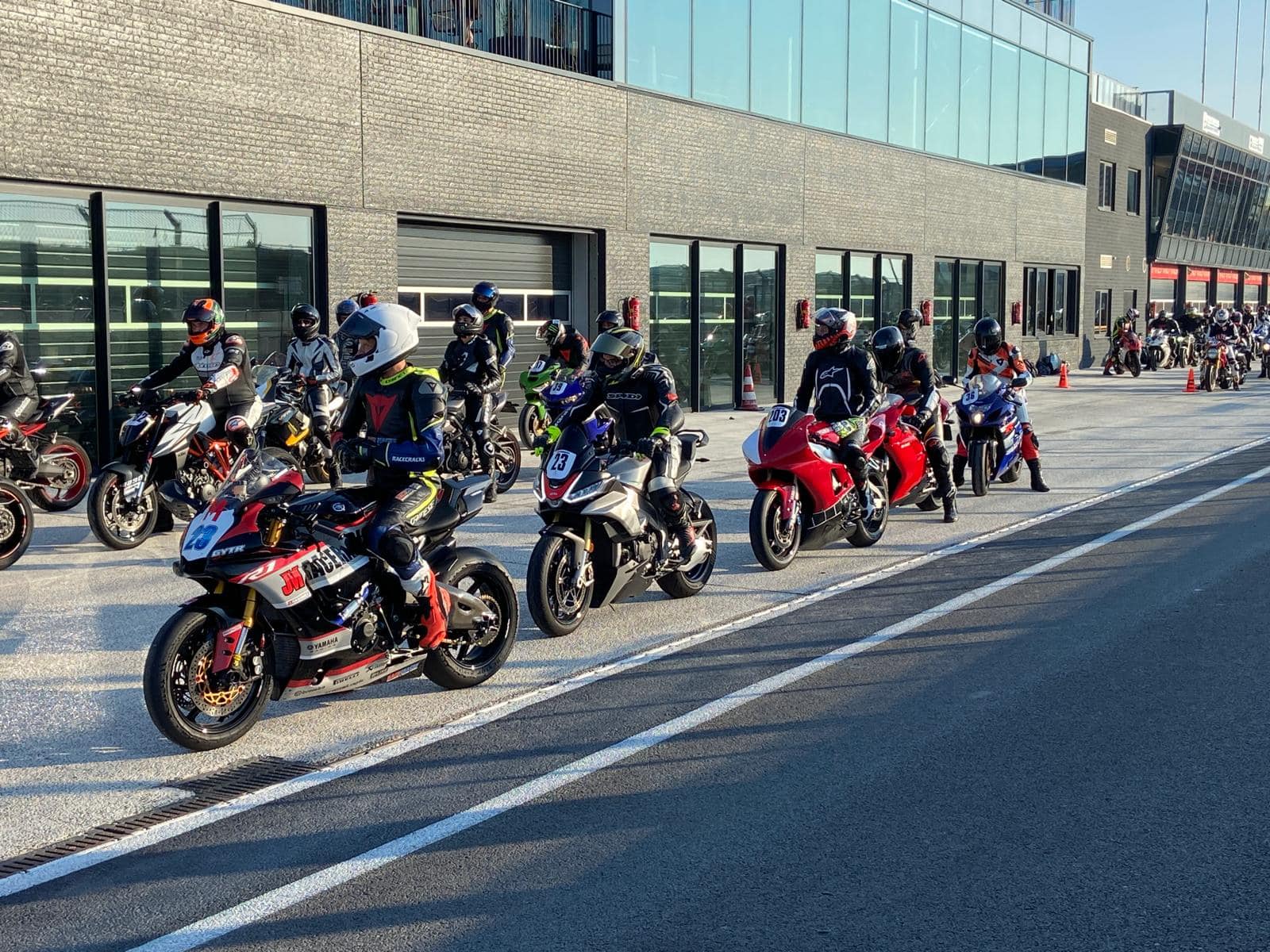 Motorrijders in de pitstraat klaar voor vertrek